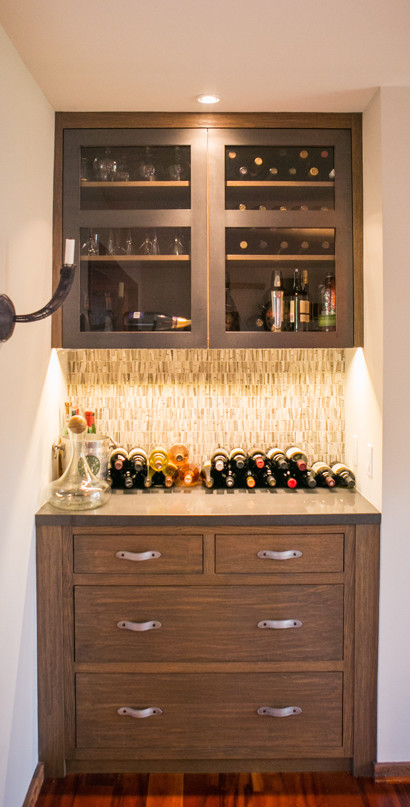 Small contemporary single-wall wet bar in San Francisco with glass-front cabinets, dark wood cabinets, solid surface benchtops, grey splashback, mosaic tile splashback, medium hardwood floors and brown floor.