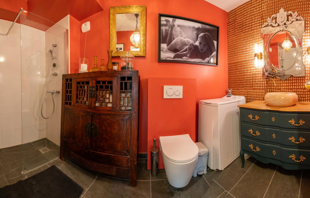 Design ideas for a mid-sized contemporary master bathroom in Paris with a curbless shower, a wall-mount toilet, orange walls, cement tiles, a pedestal sink, wood benchtops, grey floor, an open shower and a single vanity.
