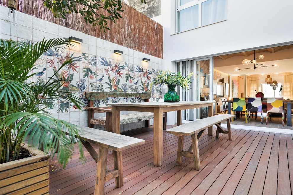 Diseño de terraza exótica grande en patio trasero con jardín de macetas y entablado
