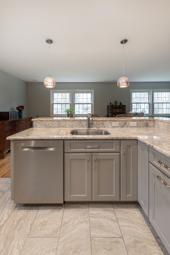 Mid-sized transitional l-shaped open plan kitchen in Boston with an undermount sink, recessed-panel cabinets, grey cabinets, quartz benchtops, white splashback, glass tile splashback, stainless steel appliances, porcelain floors, with island, grey floor and multi-coloured benchtop.