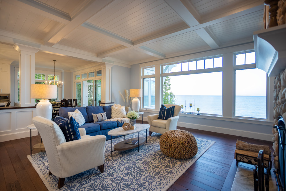 This is an example of a large traditional open concept living room in Other with blue walls, dark hardwood floors, a standard fireplace, a stone fireplace surround, a built-in media wall, brown floor and coffered.