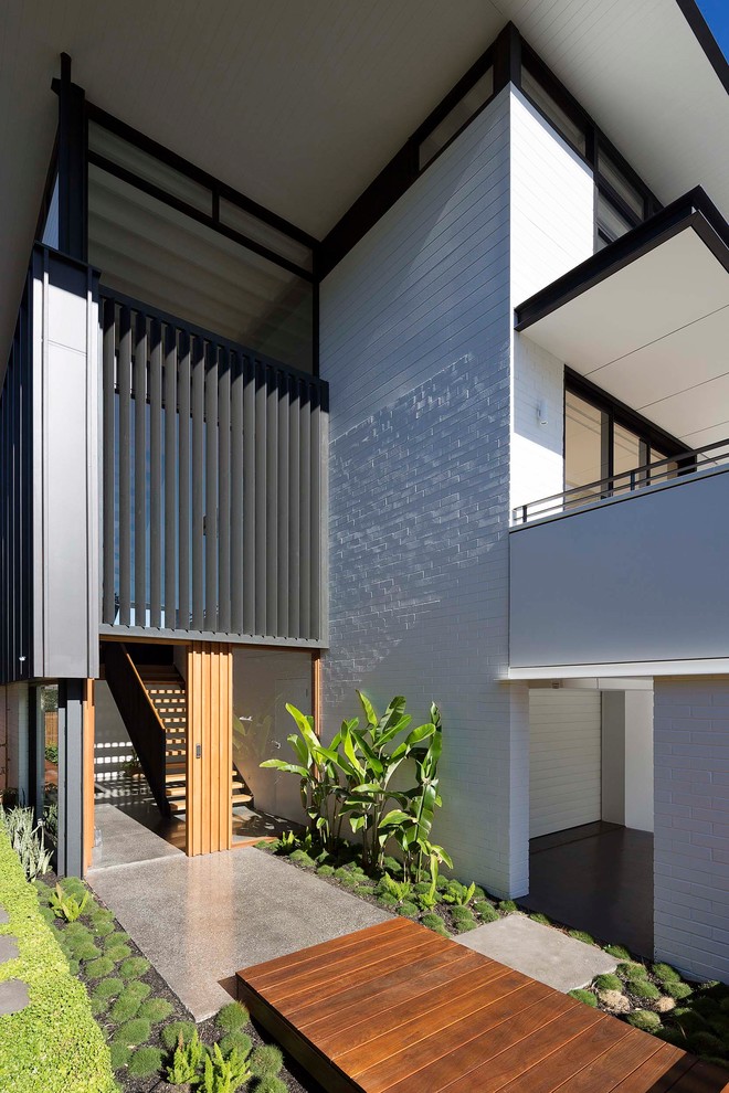 Inspiration for a large contemporary three-storey white house exterior in Sydney with a flat roof and a metal roof.