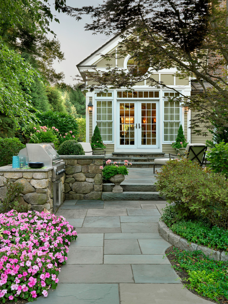 Inspiration for a mid-sized traditional backyard partial sun garden in Boston with a fire feature and natural stone pavers.