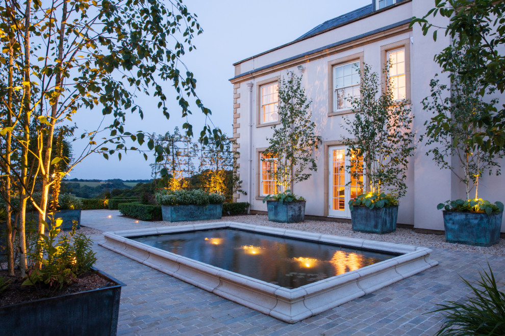 Inspiration for an expansive traditional courtyard full sun garden for summer in Oxfordshire with natural stone pavers.