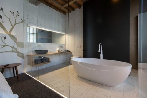 Freestanding bathtub - small eclectic master gray tile and ceramic tile freestanding bathtub idea in Chicago with a vessel sink, open cabinets, light wood cabinets, wood countertops and a wall-mount toilet