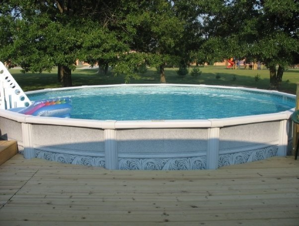 Photo of a mid-sized traditional backyard round aboveground pool in St Louis with decking.