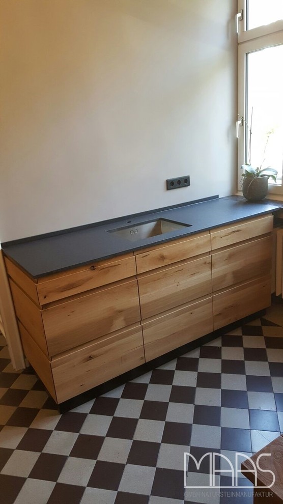 Photo of a contemporary galley kitchen in Cologne with an undermount sink, medium wood cabinets and granite benchtops.