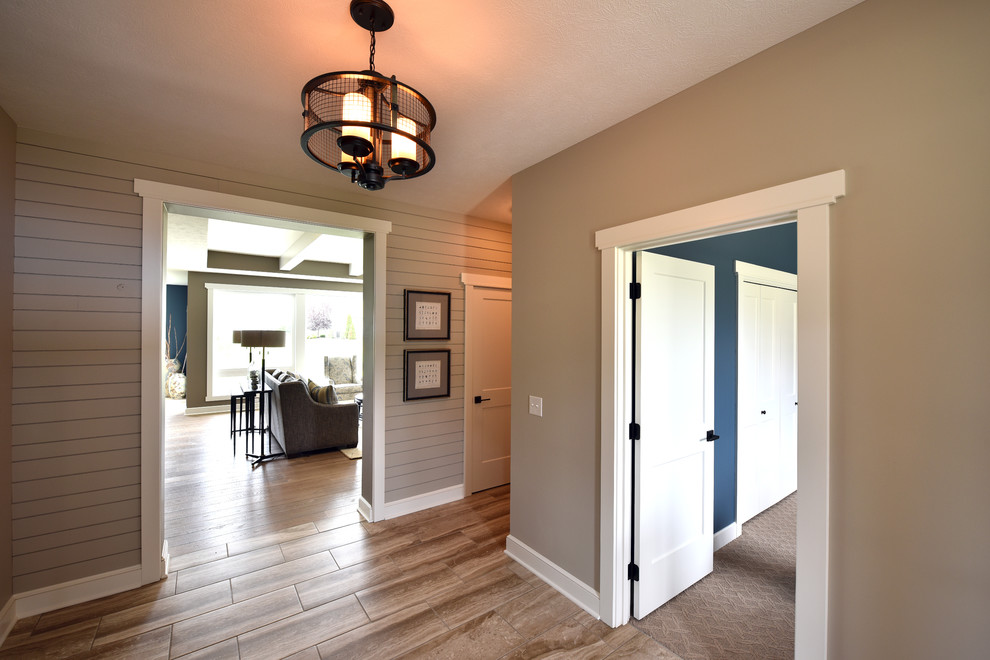 Foyer - multicolored floor and shiplap wall foyer idea with beige walls