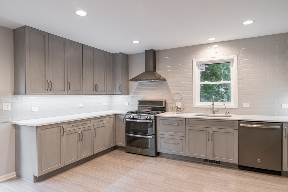 Enclosed kitchen - mid-sized transitional u-shaped vinyl floor and gray floor enclosed kitchen idea in Chicago with an undermount sink, recessed-panel cabinets, gray cabinets, quartzite countertops, gray backsplash, ceramic backsplash, stainless steel appliances and no island