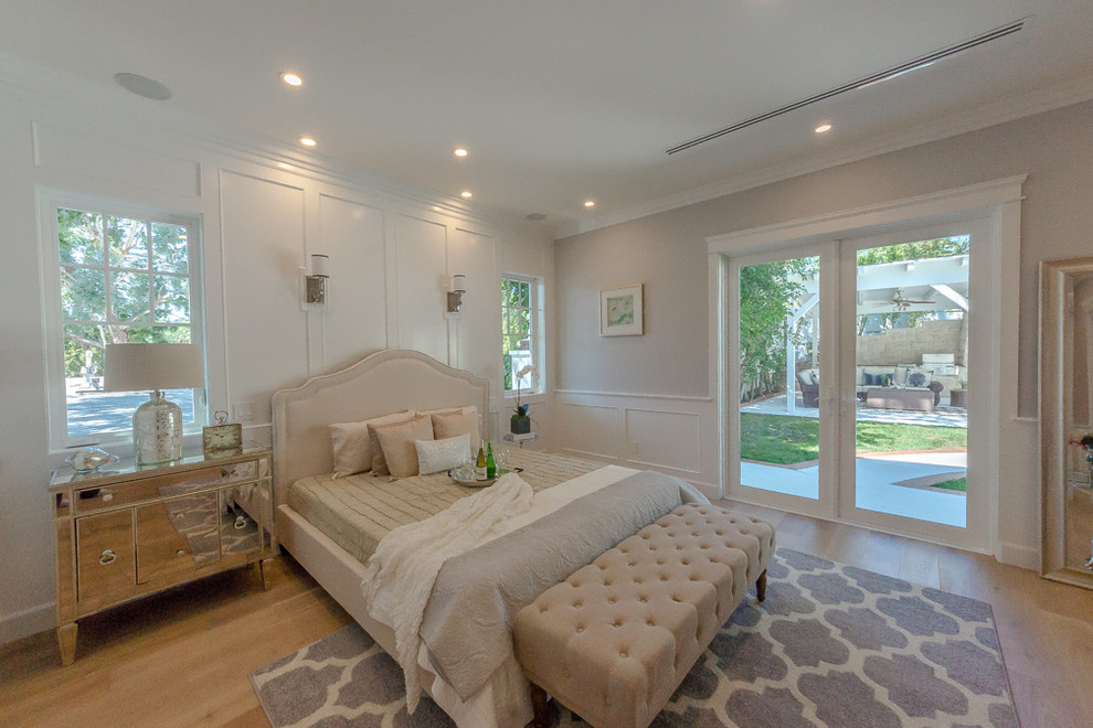 Inspiration for a large contemporary master bedroom in Los Angeles with grey walls, medium hardwood floors, a standard fireplace and a wood fireplace surround.