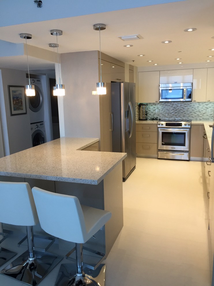Mid-sized modern u-shaped kitchen pantry in Miami with an undermount sink, flat-panel cabinets, white cabinets, recycled glass benchtops, grey splashback, glass tile splashback, stainless steel appliances, porcelain floors and a peninsula.