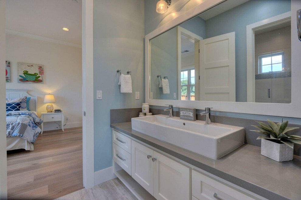 Mid-sized transitional kids bathroom in San Francisco with shaker cabinets, white cabinets, engineered quartz benchtops, an alcove shower, a trough sink, a hinged shower door and grey benchtops.