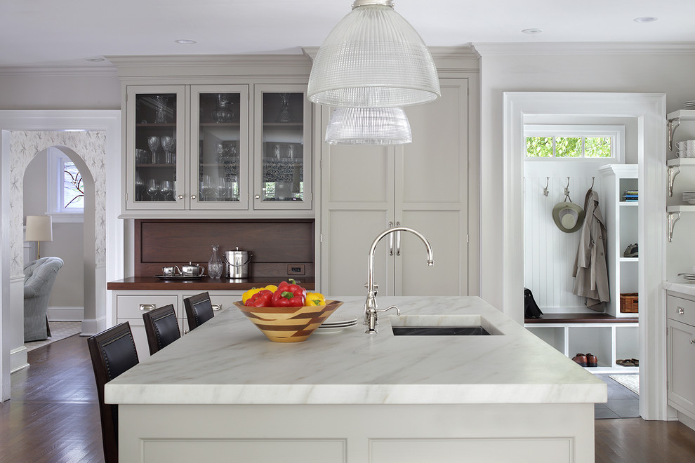 Inspiration for a large transitional l-shaped medium tone wood floor and brown floor enclosed kitchen remodel in Newark with an undermount sink, beaded inset cabinets, white cabinets, marble countertops, brown backsplash, wood backsplash, stainless steel appliances and an island
