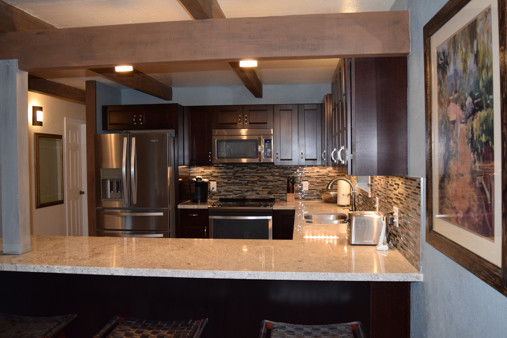 Inspiration for a mid-sized rustic u-shaped eat-in kitchen remodel with an undermount sink, recessed-panel cabinets, dark wood cabinets, granite countertops, multicolored backsplash, stainless steel appliances and a peninsula