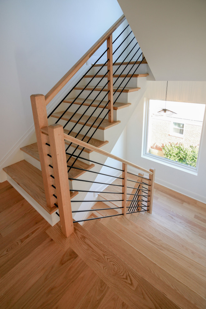 На фото: лестница на больцах, среднего размера в современном стиле с деревянными ступенями, крашенными деревянными подступенками, перилами из смешанных материалов и стенами из вагонки
