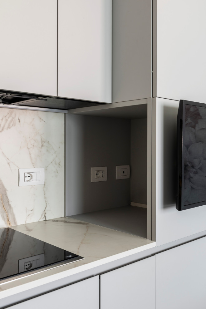 This is an example of a small contemporary l-shaped separate kitchen in Milan with an undermount sink, flat-panel cabinets, porcelain floors and grey floor.