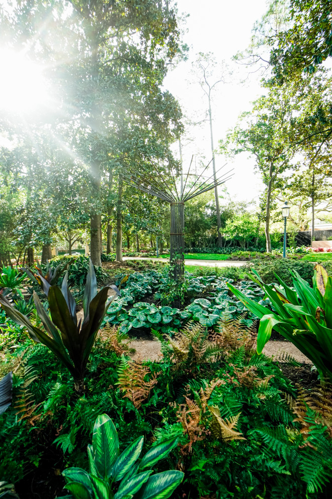 Inspiration för en mellanstor tropisk trädgård i delvis sol på våren, med en trädgårdsgång och marksten i tegel