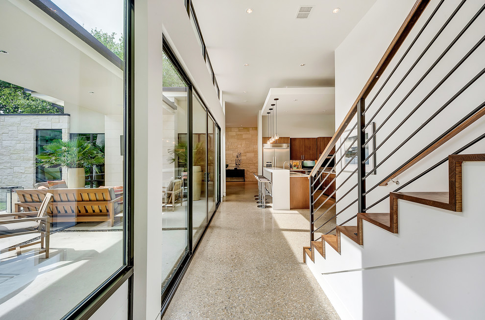 Photo of a mid-sized modern hallway in Dallas with white walls and concrete floors.