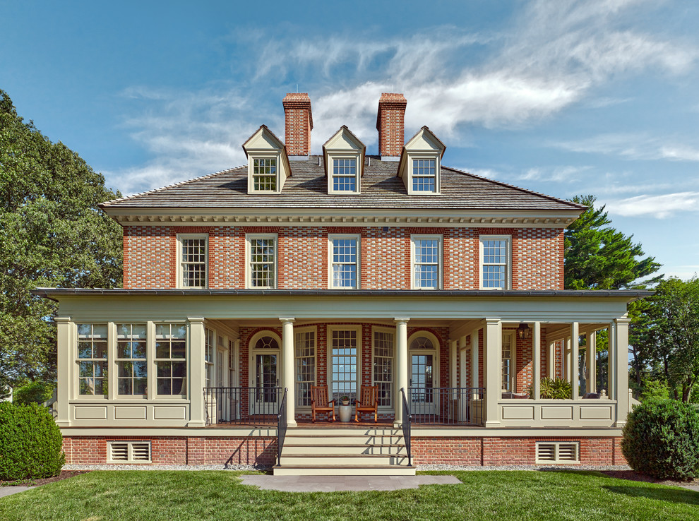 Photo of a traditional two-storey brick red house exterior in Baltimore with a hip roof and a shingle roof.