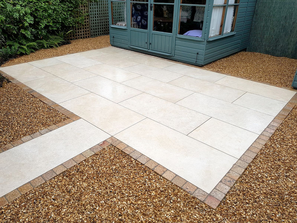 Photo of a mid-sized modern backyard patio in Oxfordshire with tile and no cover.
