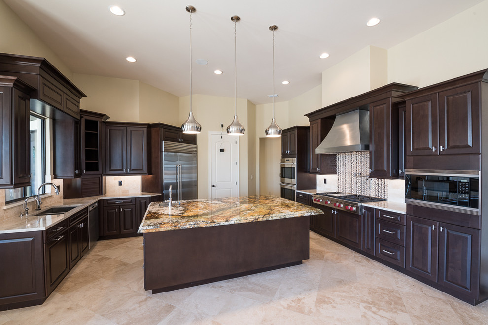 Photo of a large transitional u-shaped eat-in kitchen in Orlando with raised-panel cabinets, dark wood cabinets, granite benchtops, beige splashback, mosaic tile splashback, stainless steel appliances, travertine floors and with island.