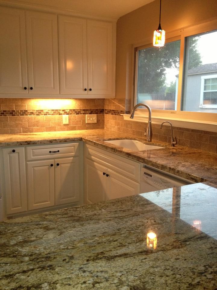 Example of a mid-sized classic u-shaped eat-in kitchen design with no island, flat-panel cabinets, white cabinets, granite countertops, beige backsplash, ceramic backsplash, white appliances, an undermount sink, beige walls and engineered wood floors