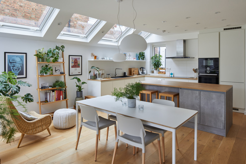 Источник вдохновения для домашнего уюта: кухня-столовая среднего размера в современном стиле с белыми стенами, светлым паркетным полом и коричневым полом