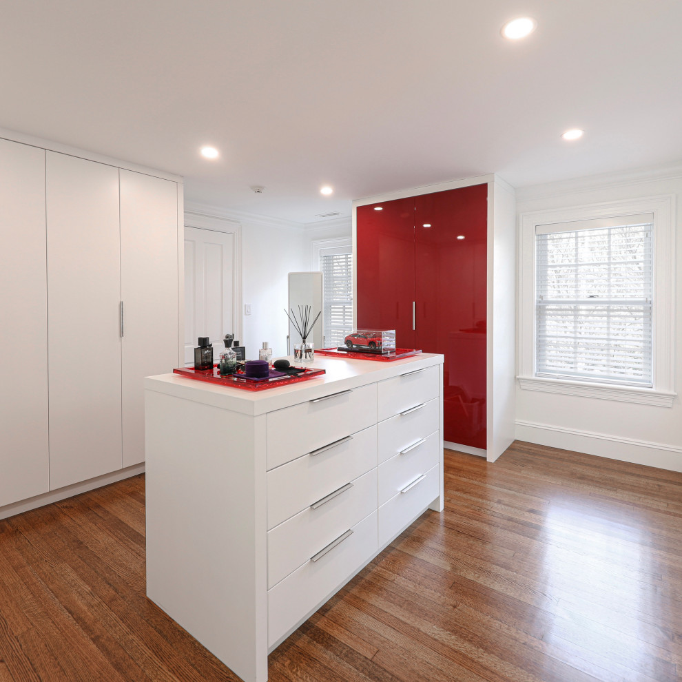 Photo of a large contemporary gender-neutral walk-in wardrobe in Boston with flat-panel cabinets, red cabinets and medium hardwood floors.