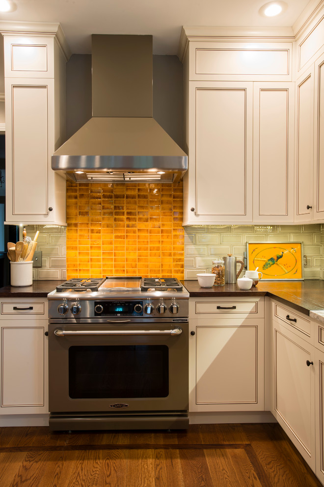 Mid-sized transitional u-shaped medium tone wood floor eat-in kitchen photo in New York with an undermount sink, recessed-panel cabinets, white cabinets, subway tile backsplash, stainless steel appliances, a peninsula, granite countertops and beige backsplash