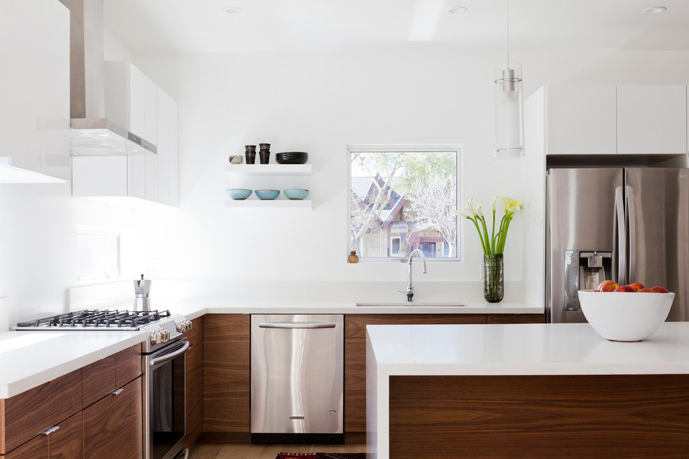 This is an example of a contemporary kitchen in Los Angeles with flat-panel cabinets, medium wood cabinets and quartzite benchtops.