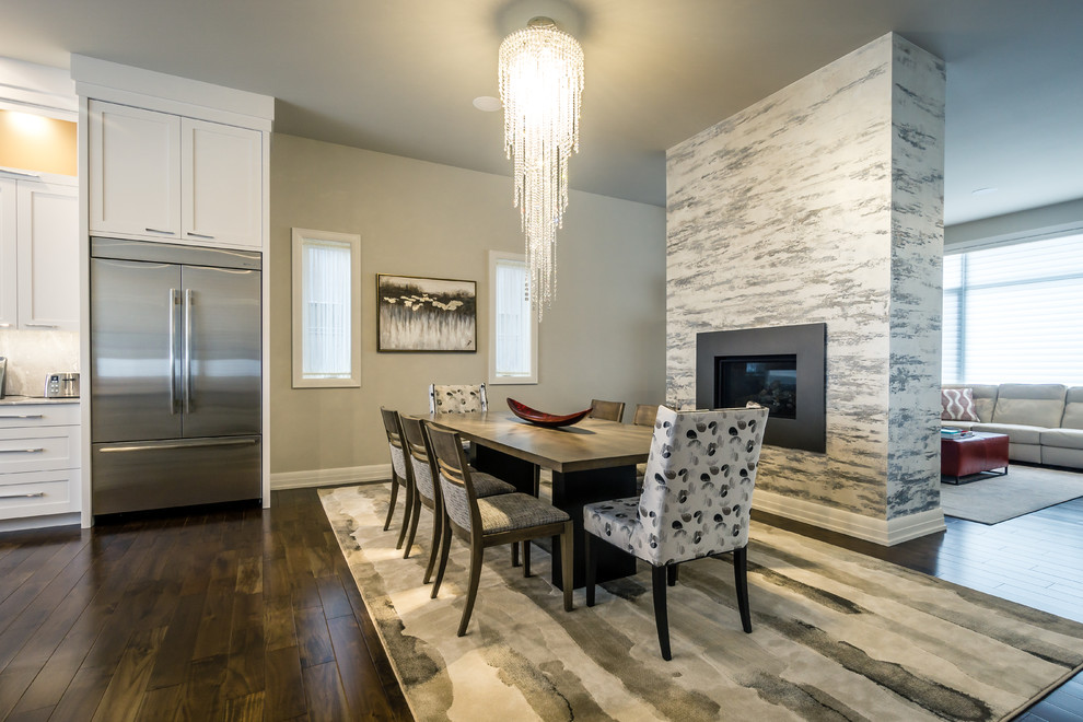 Kitchen/dining room combo - transitional dark wood floor and brown floor kitchen/dining room combo idea in Calgary with gray walls and a standard fireplace