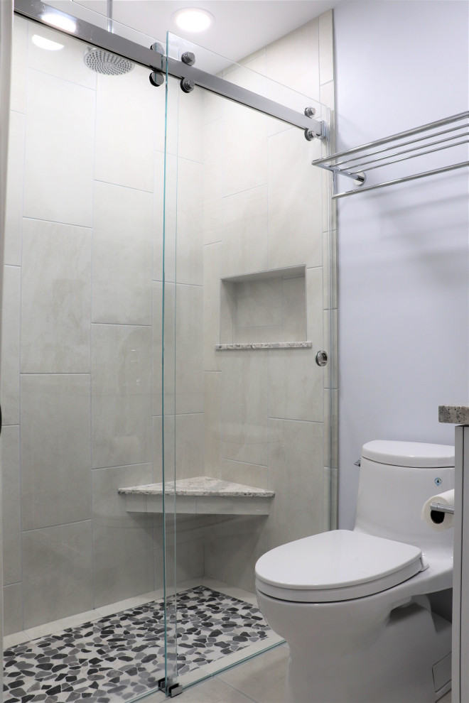 Exemple d'une douche en alcôve moderne pour enfant avec WC à poser, un carrelage gris, des carreaux de céramique, un mur gris, un sol beige et une cabine de douche à porte coulissante.