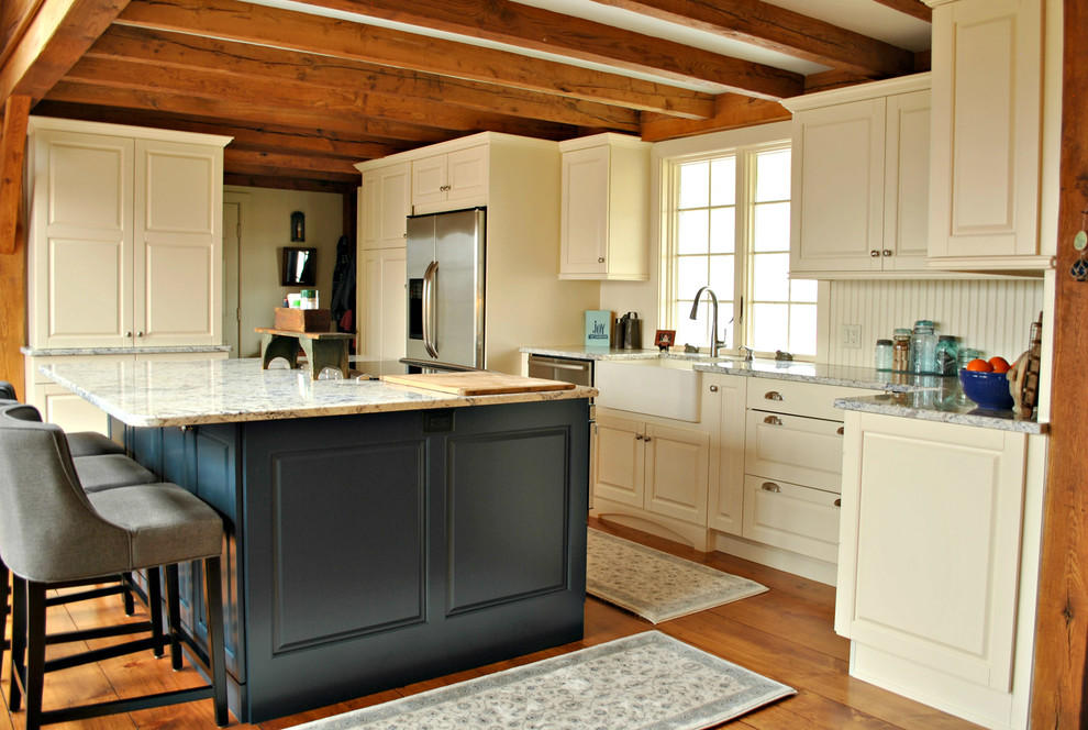 Mid-sized mountain style l-shaped medium tone wood floor and brown floor eat-in kitchen photo in Boston with a farmhouse sink, raised-panel cabinets, blue cabinets, granite countertops, beige backsplash, wood backsplash, stainless steel appliances and an island