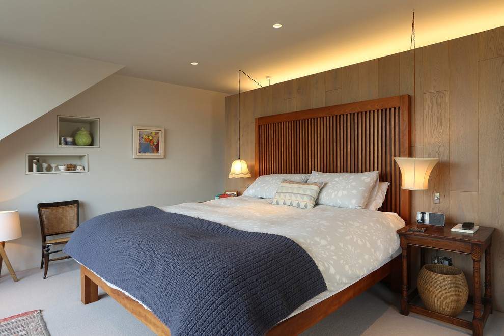 This is an example of a large contemporary master bedroom in London with beige walls, carpet, no fireplace and grey floor.