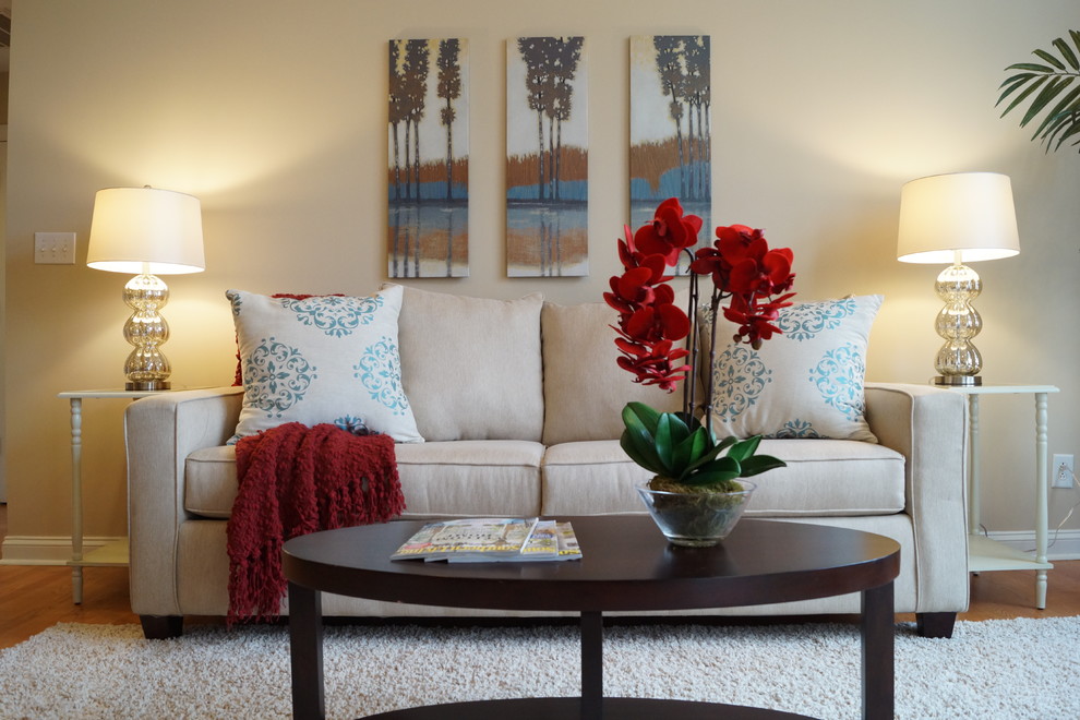 This is an example of a small traditional living room in Charlotte with beige walls and light hardwood floors.