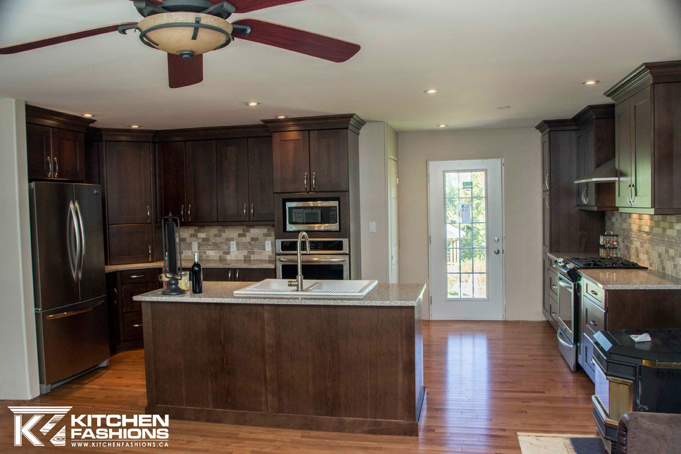 Inspiration for a large transitional u-shaped medium tone wood floor open concept kitchen remodel with a farmhouse sink, shaker cabinets, dark wood cabinets, quartz countertops, brown backsplash, stone tile backsplash, stainless steel appliances and an island