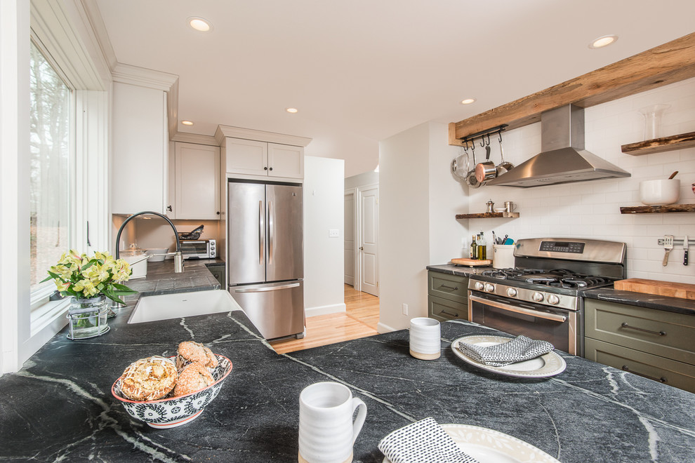 Example of a mid-sized transitional l-shaped eat-in kitchen design in Boston with recessed-panel cabinets, green cabinets, soapstone countertops, white backsplash, subway tile backsplash, stainless steel appliances and a peninsula