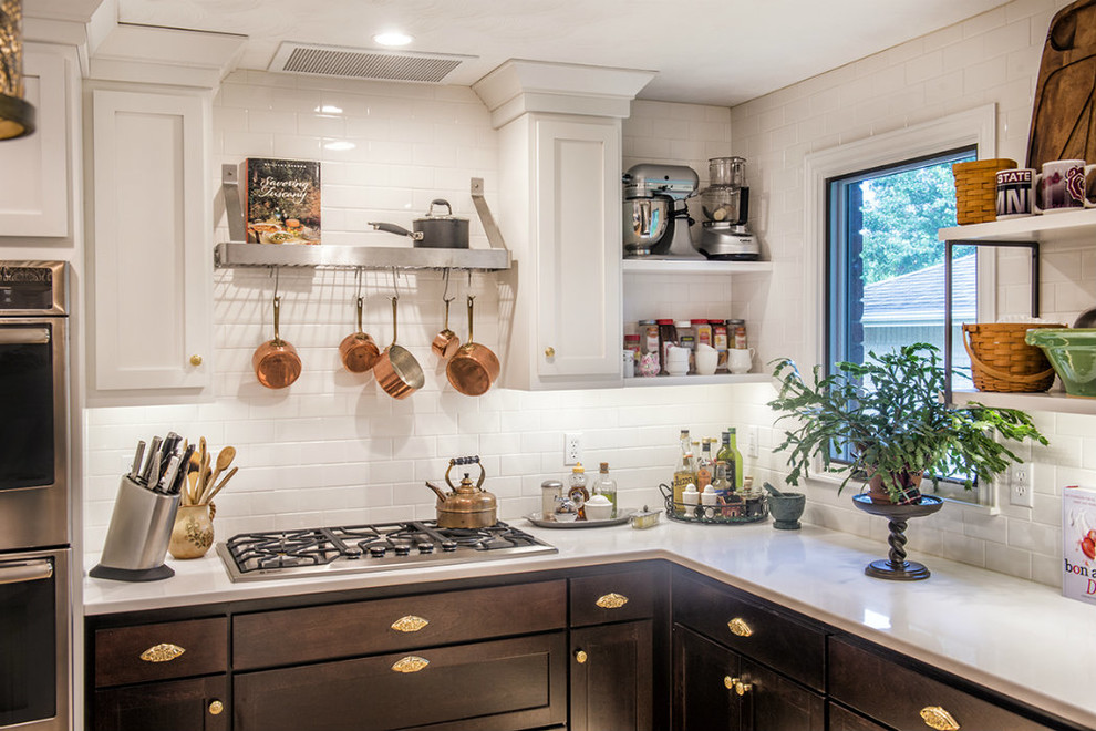 Example of a mid-sized transitional kitchen design with shaker cabinets, dark wood cabinets, white backsplash, subway tile backsplash and stainless steel appliances
