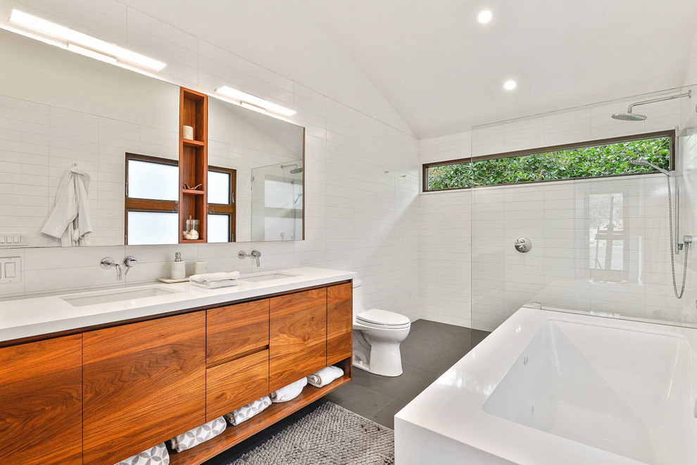 Inspiration for a large modern master bathroom in San Francisco with flat-panel cabinets, medium wood cabinets, an undermount tub, a curbless shower, a one-piece toilet, white tile, ceramic tile, white walls, ceramic floors, an undermount sink, engineered quartz benchtops, grey floor and an open shower.