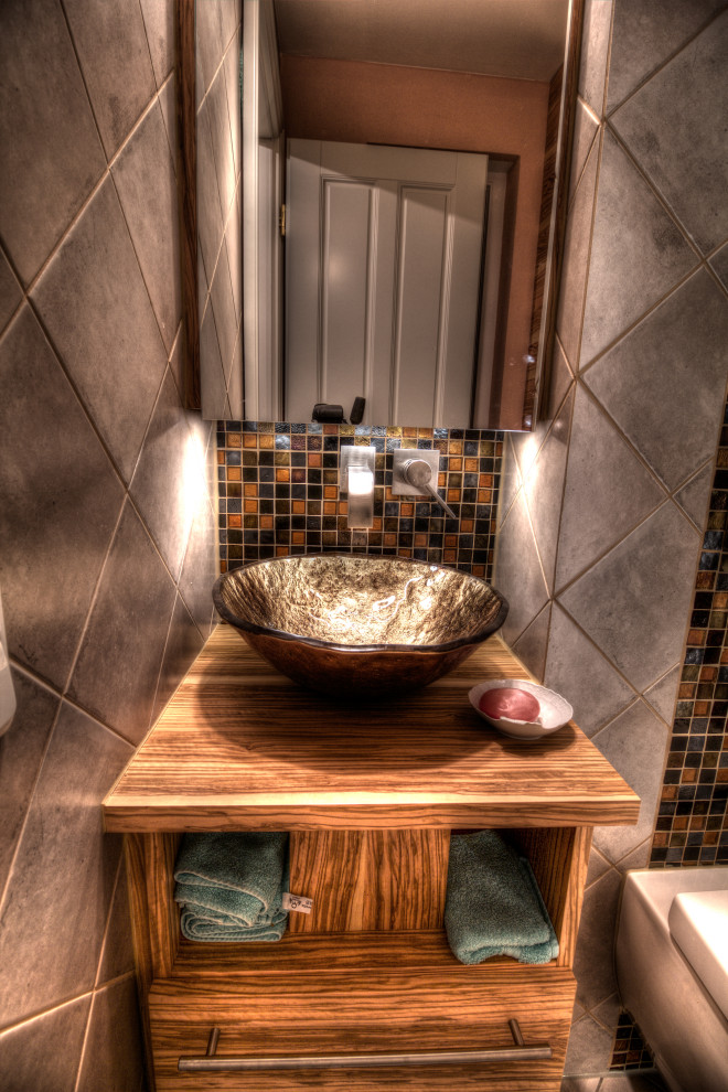 Aménagement d'un petit WC suspendu classique en bois brun avec un placard à porte plane, un carrelage beige, mosaïque, un mur beige, un sol en carrelage de céramique, une vasque, un plan de toilette en verre, un sol beige, un plan de toilette marron, meuble-lavabo suspendu et un plafond décaissé.