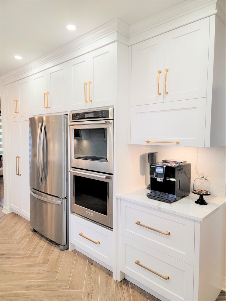 Eat-in kitchen - mid-sized transitional galley porcelain tile and brown floor eat-in kitchen idea in Montreal with an undermount sink, shaker cabinets, white cabinets, quartz countertops, white backsplash, quartz backsplash, stainless steel appliances, a peninsula and white countertops