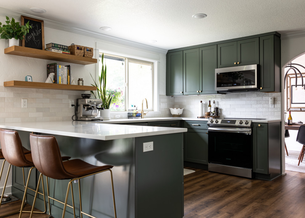Large transitional eat-in kitchen photo in Portland with shaker cabinets, white backsplash, stainless steel appliances, an island and white countertops