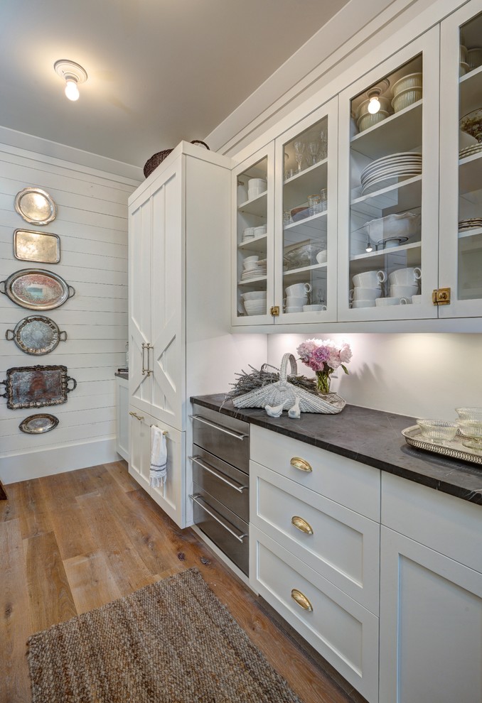 Large country single-wall eat-in kitchen in Charleston with white cabinets, marble benchtops, with island, shaker cabinets, white splashback, panelled appliances and light hardwood floors.