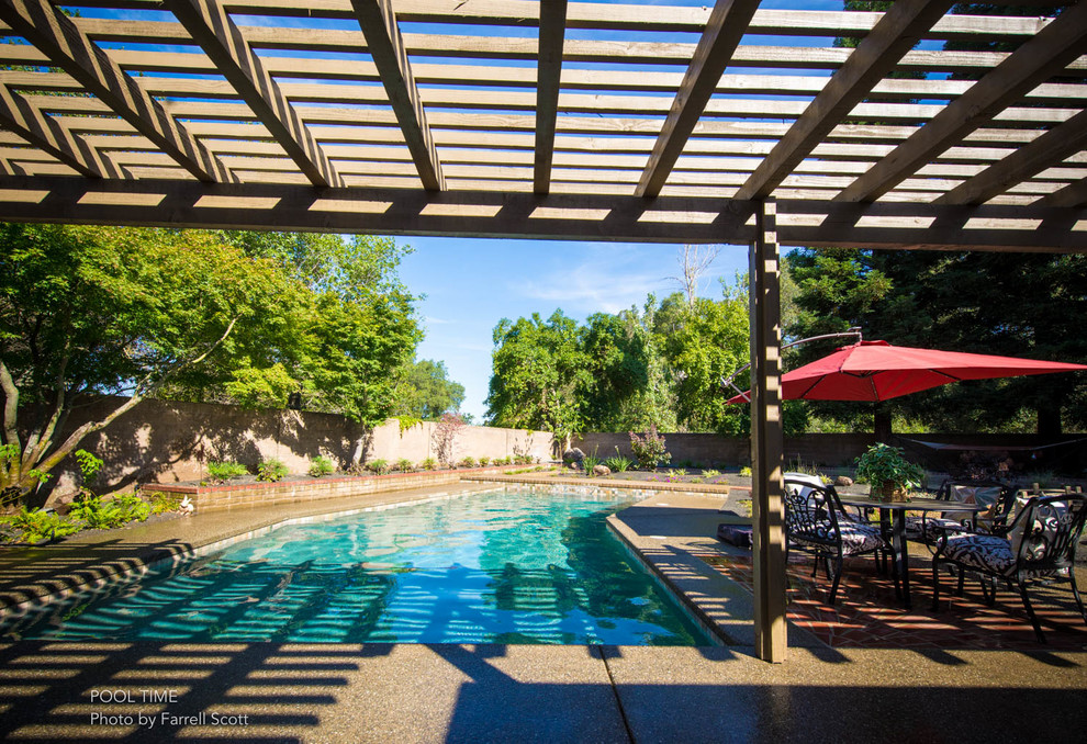 Photo of a mid-sized traditional backyard rectangular pool in Sacramento with a water feature and brick pavers.
