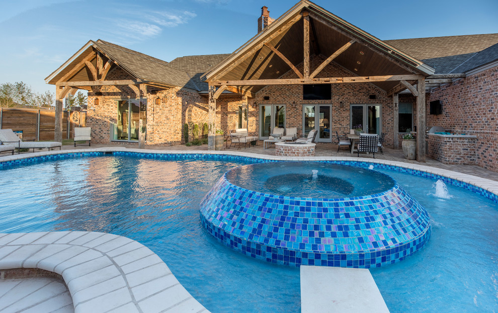 Large mountain style backyard brick and custom-shaped hot tub photo in Austin