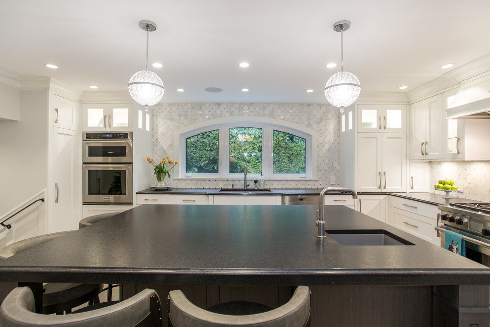 Eat-in kitchen - large transitional l-shaped medium tone wood floor and beige floor eat-in kitchen idea in Vancouver with an undermount sink, shaker cabinets, white cabinets, granite countertops, gray backsplash, marble backsplash, stainless steel appliances, an island and black countertops