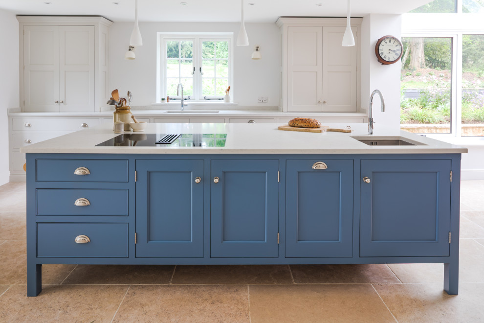 Design ideas for a traditional kitchen in Dorset with recessed-panel cabinets, limestone floors, with island and white benchtop.