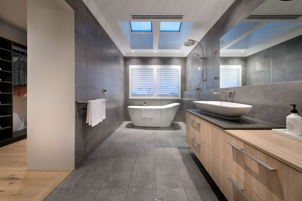 Inspiration for a contemporary master bathroom in Perth with flat-panel cabinets, light wood cabinets, a japanese tub, an open shower, gray tile, brown walls, a vessel sink, grey floor and an open shower.