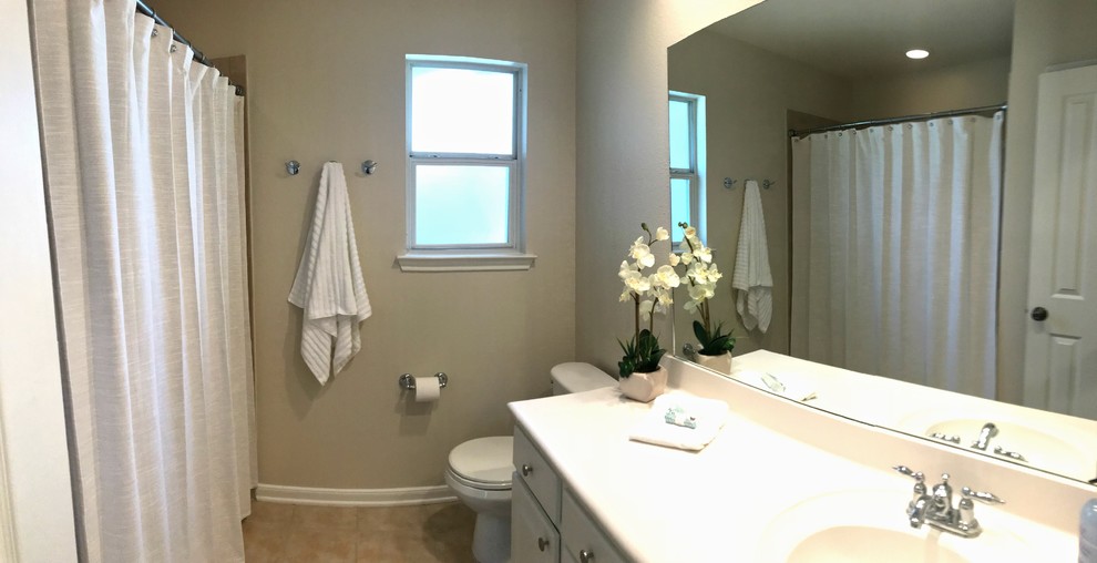 Example of a large classic 3/4 travertine floor and beige floor bathroom design in Houston with flat-panel cabinets, white cabinets, an undermount tub, beige walls and an undermount sink