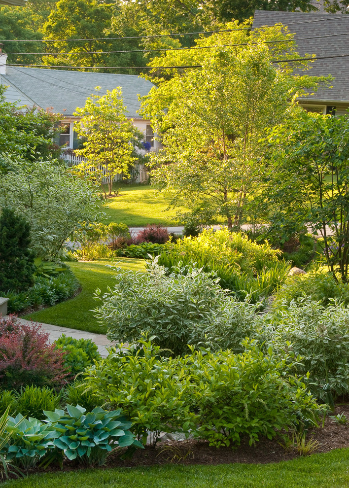 Photo of a mid-sized traditional partial sun front yard stone water fountain landscape in DC Metro for spring.